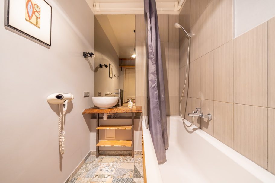 Modern bathroom featuring a bathtub, sink, and neutral colors with stylish decor.